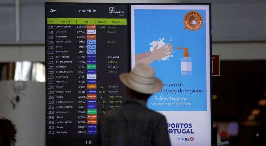 Uma pessoa a olhar para o ecrã com informação de check-in num aeroporto
